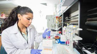 Student doing research holding a micropipette